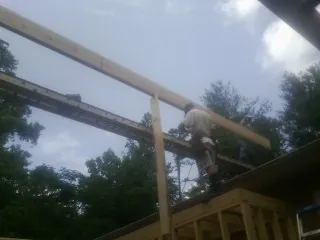 Carpenter setting a ridge beam over a new addition frame — Ice Dam Removal by Roofing Brothers in Middleport