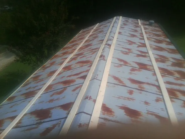 Rusted metal roof panels with new wood purlins before replacement — Storm Damage Roof Repair in Middleport by Roofing Brothers