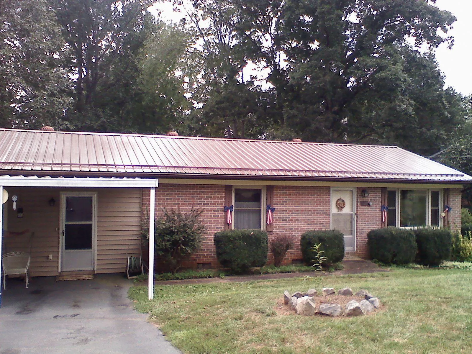 Bronze metal roof and carport on a brick ranch home — Roof Repair work by our crew in Middleport